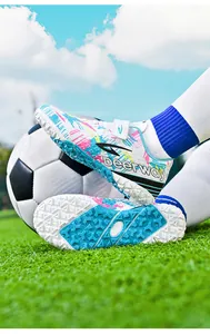 Detailed view of colorful turf soccer shoes with patterned upper and rubber studs