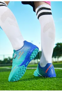 Close-up of blue children's turf soccer shoes with high-traction sole and secure strap.