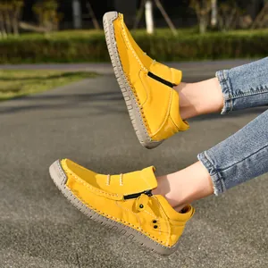 Close-up detail of yellow high-top outdoor loafers with side zipper and stitched sole
