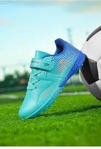 Detailed view of turquoise children's turf soccer shoes with secure velcro strap.