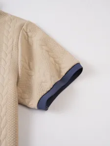 Macro detail of men's polo shirt sleeve with jacquard texture and navy ribbed cuff
