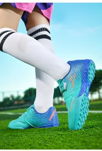 Detail view of children's turf soccer shoes with Velcro straps and Deerway logo on grass