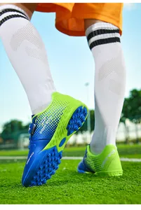 Detailed macro view of blue and lime green children's turf soccer shoes with Velcro strap.