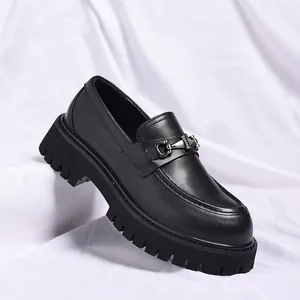 Close-up of black men's chunky leather loafer with thick platform sole and metal bit detail.