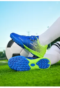 Close-up of children's TF turf soccer shoes showing sole grip and blue-green design.