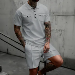 Stilvolles graues Waffelstrick-Set für Herren mit Kurzarm-Poloshirt und kurzen Hosen.
