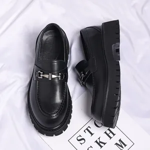 Detailed view of black leather men's loafers with chunky lug sole and metal hardware buckle