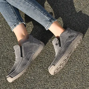 Detail of grey high-top hand-stitched men's casual shoes on outdoor ground