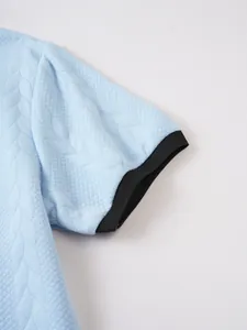 Close-up of short sleeve cuff with textured jacquard knit pattern on polo shirt