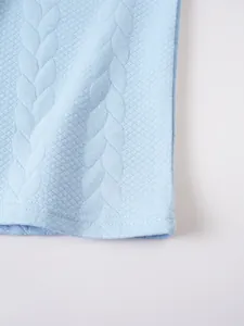 Close-up macro view of the light blue jacquard knit fabric texture on a polo shirt