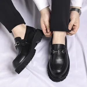 Close-up of men's black platform loafers with stylish metal bit detail design