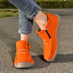 Close-up of bright orange hand-stitched high-top casual shoes with zipper for men