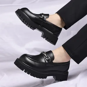 Detailed side view of men's chunky black loafers with thick sole and metal buckle