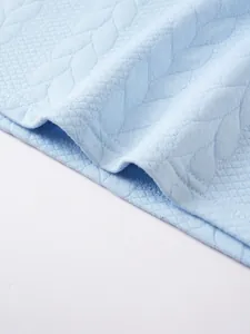 Detailed macro view of light blue jacquard textured fabric on men's business casual polo shirt