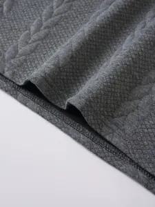 Close-up of grey jacquard fabric texture and hem stitching on men's polo shirt