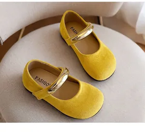 Nahaufnahme von gelben Wildleder-Mary-Janes für Mädchen mit goldener Metallschnalle