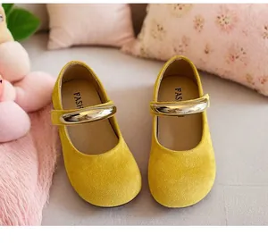 Detailansicht gelber Wildleder-Mary-Jane-Schuhe mit goldenen Riemen für Mädchen.