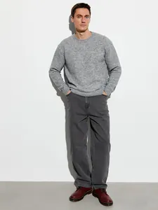 Vista completa di jeans grigi larghi a gamba dritta da uomo indossati da un modello.