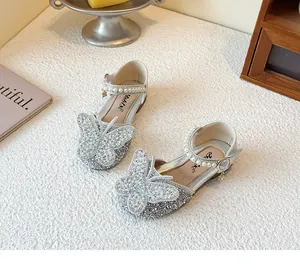 Detail showing silver glitter girls shoes with rhinestone butterfly and pearl strap