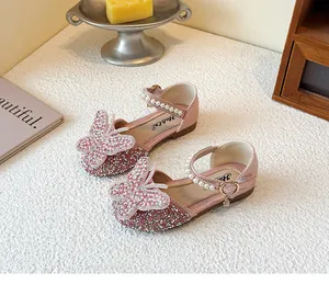 Close-up detail of pink glitter girl princess shoes with 3D butterfly and pearl buckle strap.