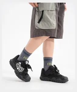 Gros plan de baskets rétro noires à plateforme avec yeux de dessin animé sur un enfant