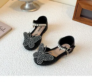 Exquisite detailed view of girls' black princess shoes with pearl-encrusted butterfly bow
