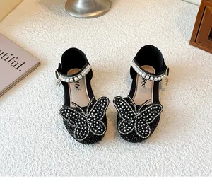 Detailed shot of girls' black rhinestone princess shoes with butterfly and pearl accents