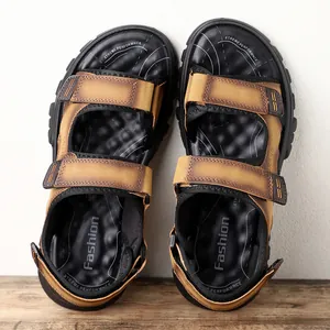 Vista superior de sandalias de hombre para exteriores en marrón con correas y suelas negras.