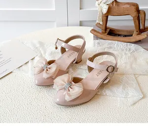 Close-up of pink girls' pointed sandals with rhinestone mesh bows and star charms.