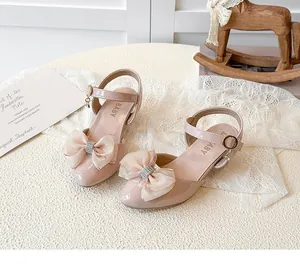 Close-up of pink girls' bow sandals with rhinestone details and a classic pointed toe