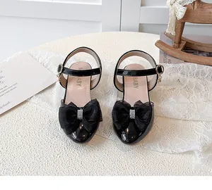 Elegant black girls' high heel sandals featuring a large mesh bow and rhinestones