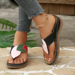 Détail de sandales compensées pour femmes avec un motif de feuilles multicolores