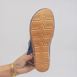 Detail der strukturierten braunen Gummisohle einer blauen Keilsandalette mit Größe 37.