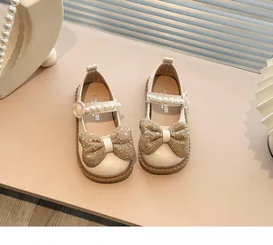 Detalle superior de zapatos Mary Jane crema para niña con lazos florales y perlas