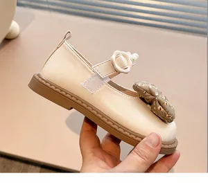 Vista detallada de zapatos Mary Jane crema para niños con lazo floral y perlas elegantes