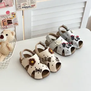 Nahaufnahme von niedlichen Mädchen-Sandalen in Creme und Silber mit weichen Sohlen und Bären