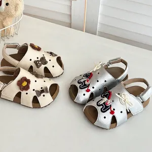 Detail von Mädchen-Sandalen mit Cartoon-Bär-Motiven und Lochmuster in Silber und Beige-Farbe