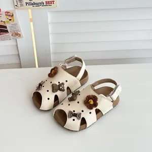 Beige Mädchen-Sandalen im Birkenstock-Stil mit niedlichen Bären- und Blumen-Anhängern im Detail