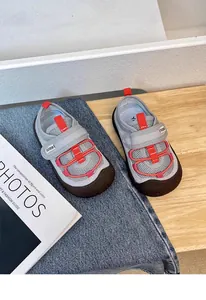 Detailed view of breathable toddler sports shoes featuring red straps and mesh fabric