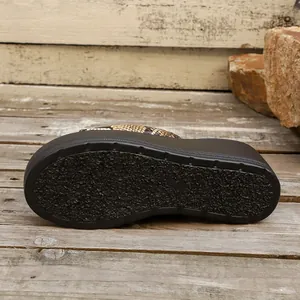 Primer plano de sandalia plataforma de serpiente con suela gruesa de goma negra antideslizante.
