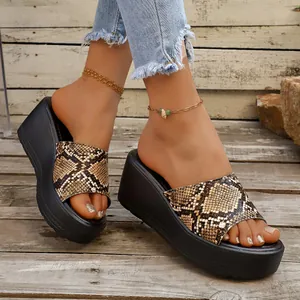 Detalle de las sandalias de cuña con estampado de serpiente y plataforma negra