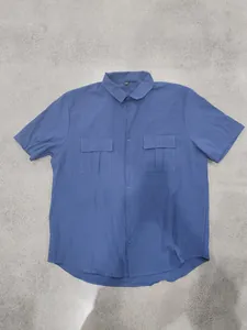 Front view of a blue men's short-sleeved linen shirt with two utility chest pockets