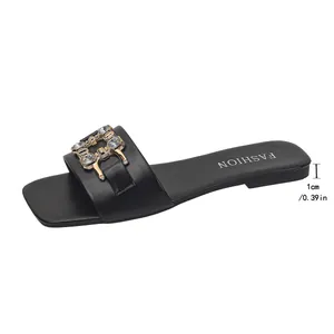 Detailed side view of black flat slide sandal with 1cm heel height and crystal buckle