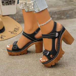 Side view detail of black platform sandals with chunky wood-grain heels and velcro straps.