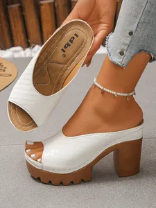 Detailansicht weißer Peeptoe-Plateausandalen mit braunem Blockabsatz und strukturierter Oberfläche