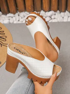 Detailansicht weißer gesteppter Peep-Toe-Mules mit klobigen braunen Plateau-Absätzen