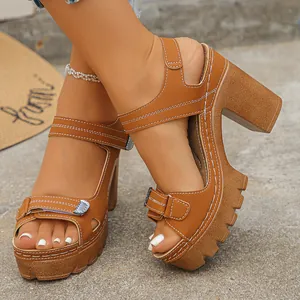 Chunky tan platform sandals featuring thick heels and adjustable velcro straps detail