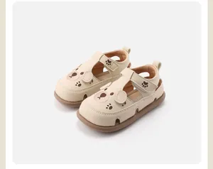 Detailweergave van beige peutersandalen met schattig berengezicht en pootafdruk