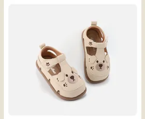 Gedetailleerd aanzicht van beige peutersandalen met schattig berengezicht en zacht leer.