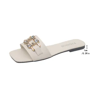 Detail view of beige square toe flat slippers featuring rhinestone chain and 1cm low heel